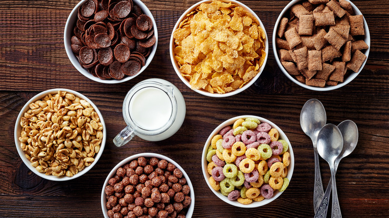 Six bowls around a milk jug, filled with different cereals.