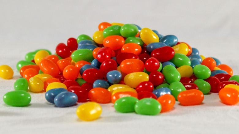Pile of multicolored jelly beans photographed against a grey background