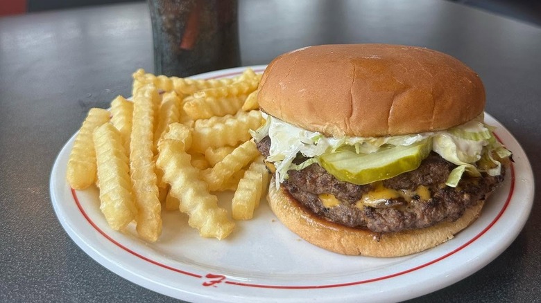 A mashed Boy Burger from Frisch's Big Biy on a plate with crinkle fries