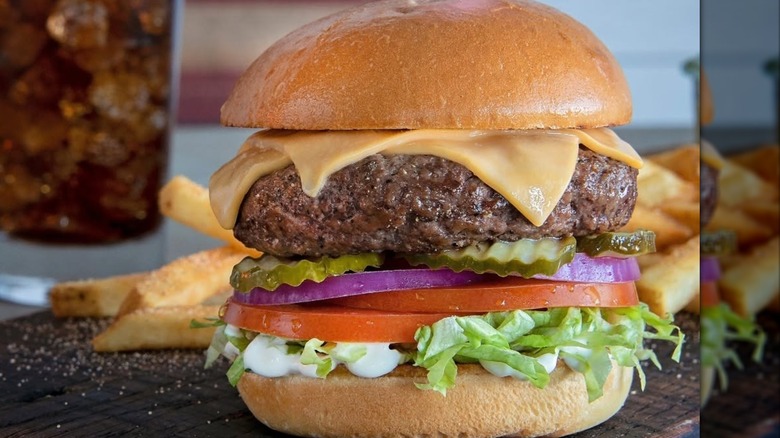 A Shoney's All-American burger showing a thick patty with cheese, pickles, onion, tomato, and lettuce