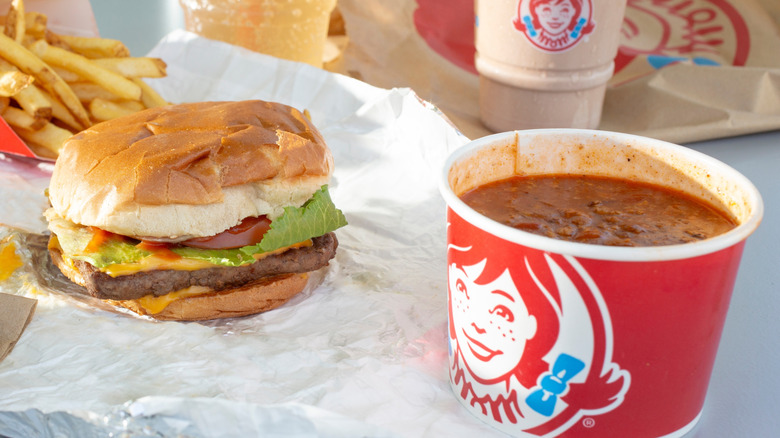 Wendy's cheeseburger sitting next to Wendy's chili