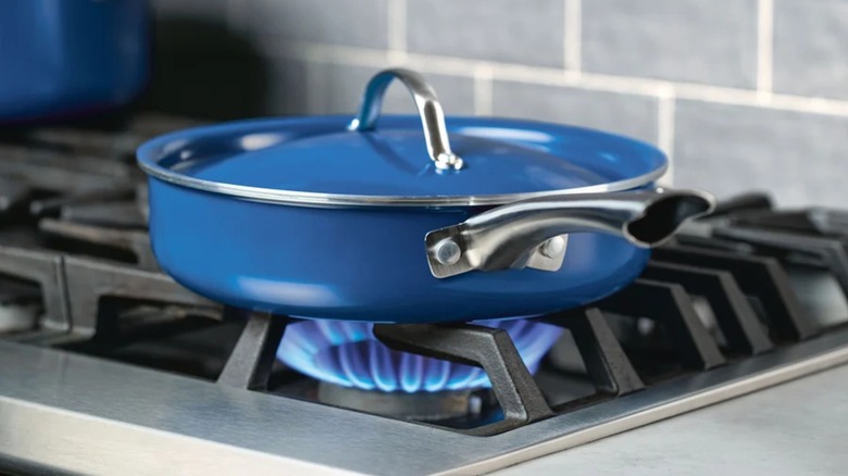 Farberware Vibrance saute pan in navy on lit gas stovetop.