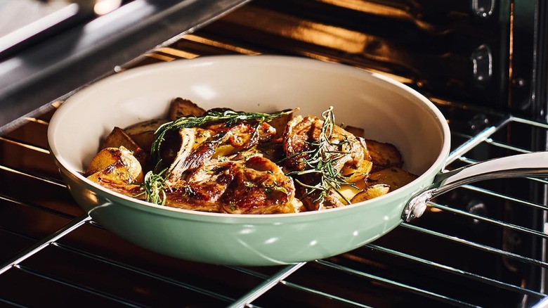 RedChef ceramic frying pan in sage green in an oven with baked vegetables inside.