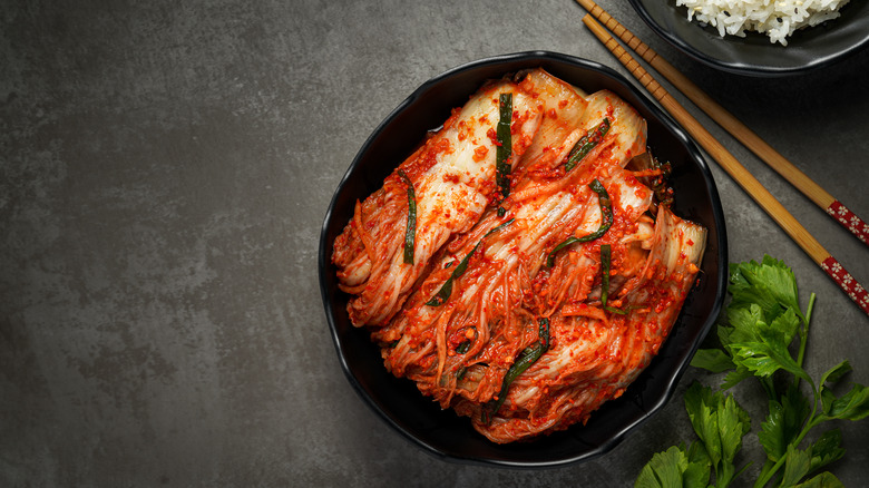A bowl of kimchi with chopsticks