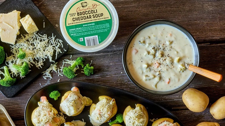 Trader Joe's Unexpected Broccoli Cheddar Soup on a table with prepared apetizers