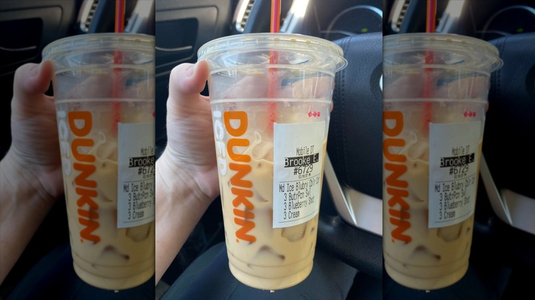 Hand holding cup of Dunkin' Blueberry Cobbler Coffee