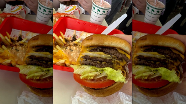 Hand holding In-N-Out Burger 4x4 over red tray