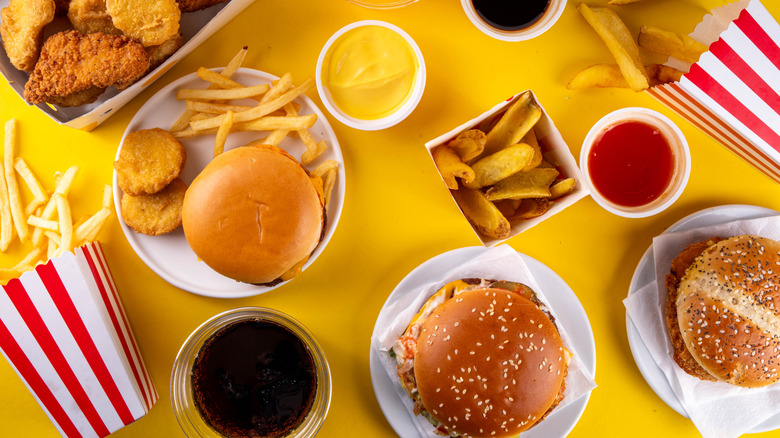 Variety of fast food dishes on yellow table