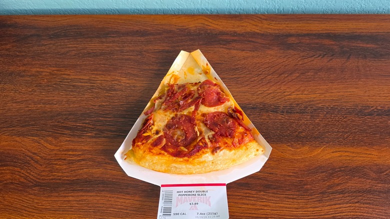 Hot honey double pepperoni pizza slice on paper holder with taste missing