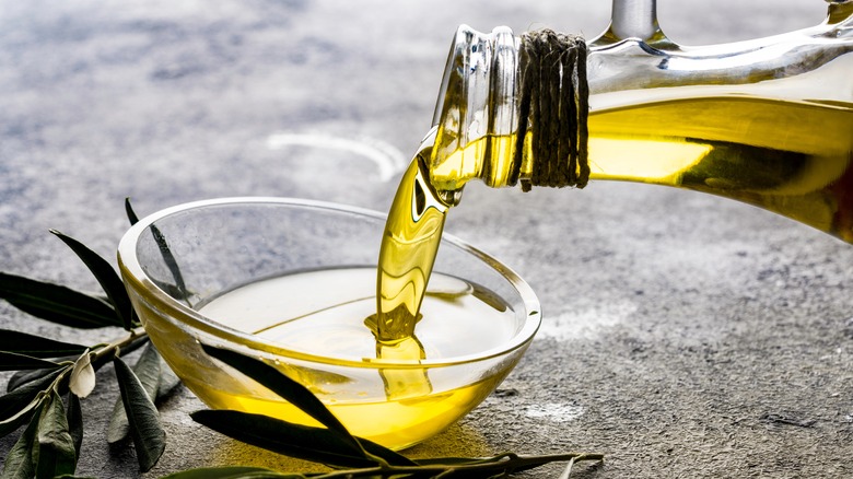 pouring olive oil into a small glass bowl