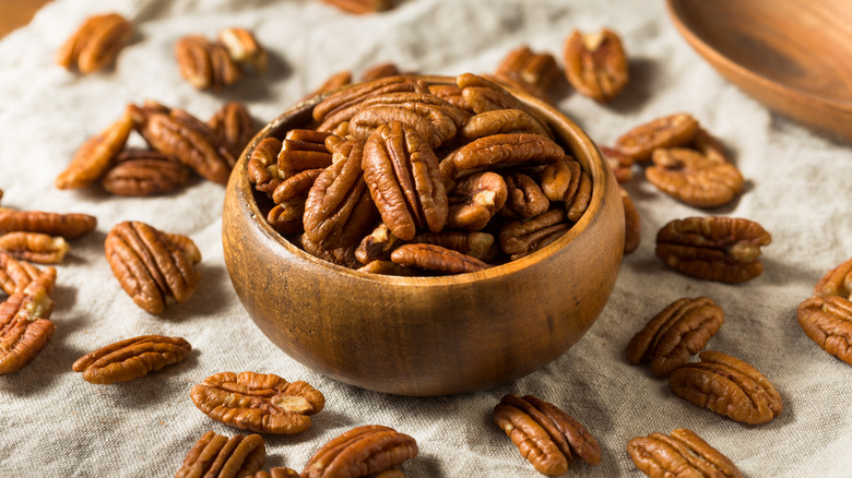 shelled pecan halves in wooden bowl