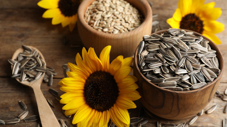 bowls of shelled and whole sunflower seeds with flowers