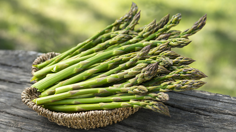 many stalks of asparagus in a woven basket