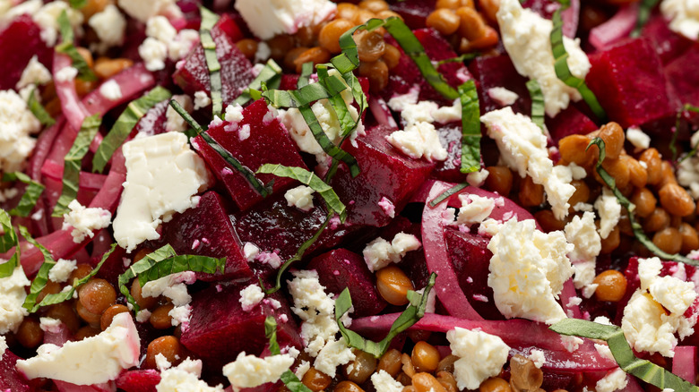 a close-up of a red beet salad with herbs and cheese