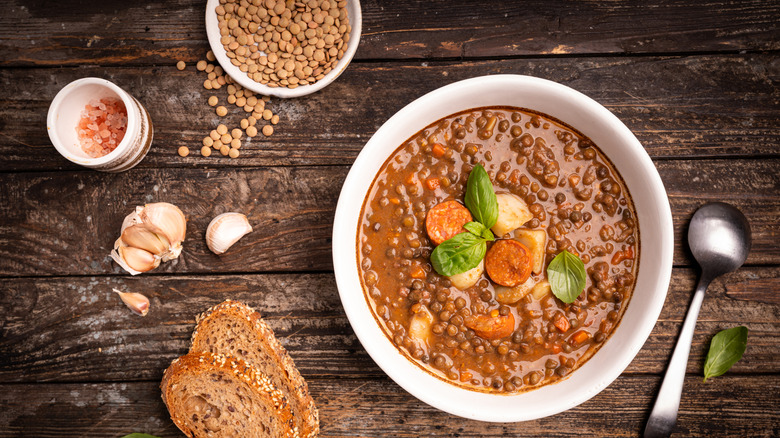 a bowl of brown lentil stew with ingredients alongside