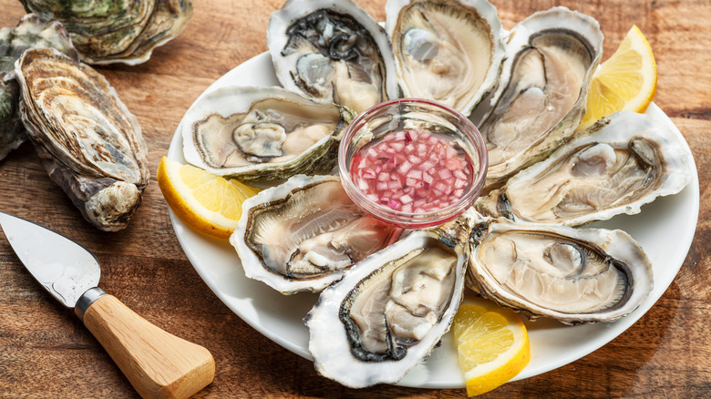 a tray of oysters on the half shell garnished with lemons