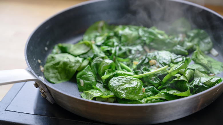 a pan of spinach cooking on the stove