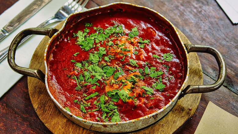 stewed tomatoes and herbs in a pot with handles