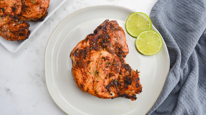 Grilled pork chop with lime slices on plate