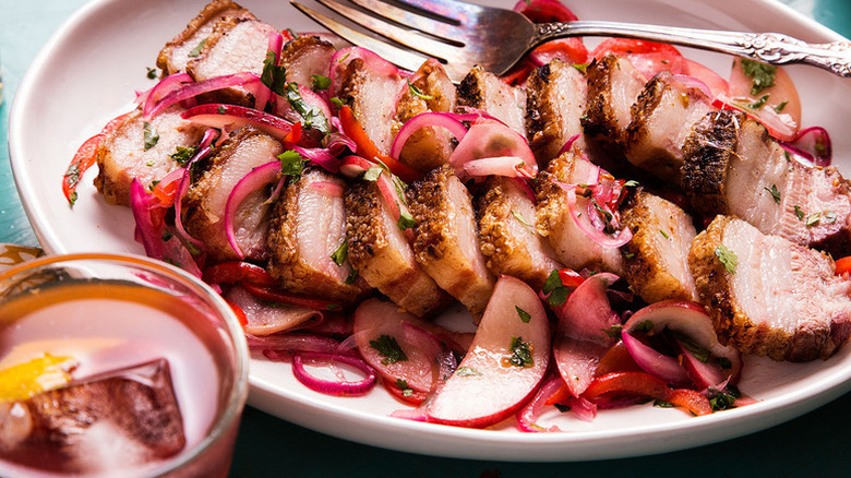 Sliced pork belly topped with peach salsa