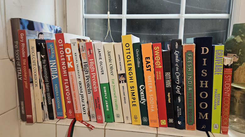 Cookbooks lined up on windowsill.