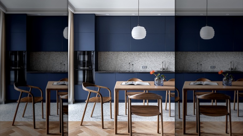 Kitchen with dark blue cabinets and two different styles of flooring