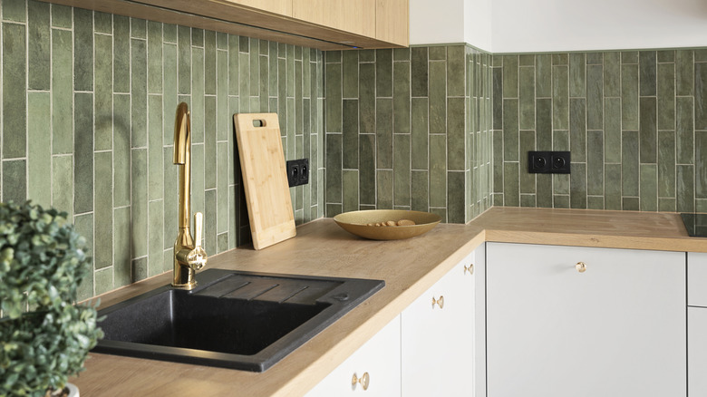 Wooden countertop with vertical green subway tile backsplash