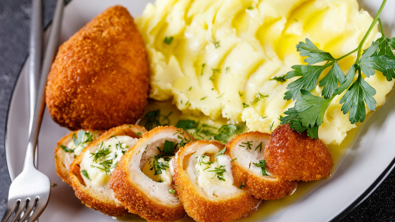 sliced chicken Kiev with mashed potatoes