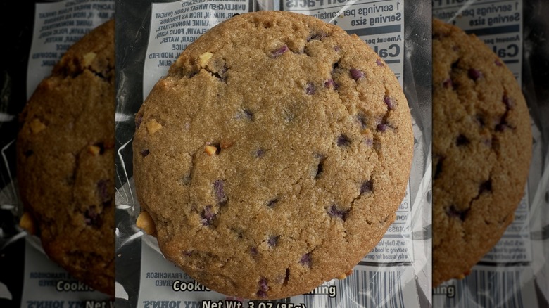 Around Brown cookie with visible peanut bits and purple jelly spots