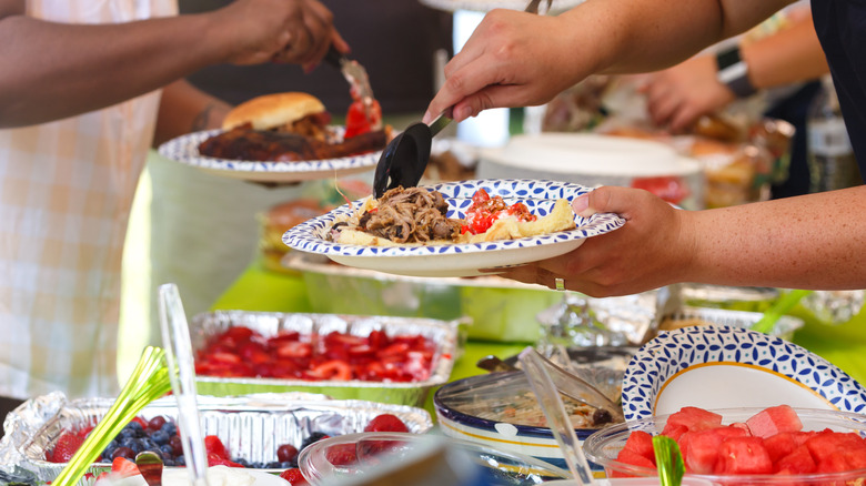 People putting food on their plates at a potluck