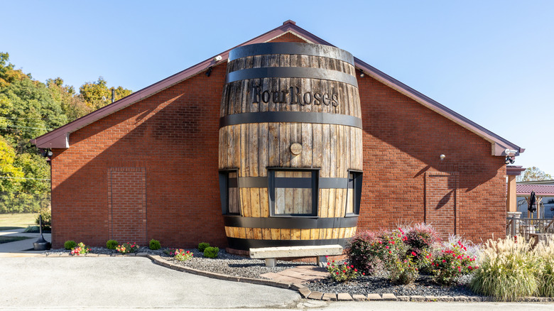 A shot from outside of the Four Roses distillery showing its name on a giant barrel