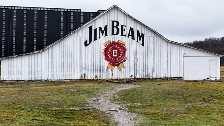 The Jim Beam logo and writing on the side of a large white painted warehouse