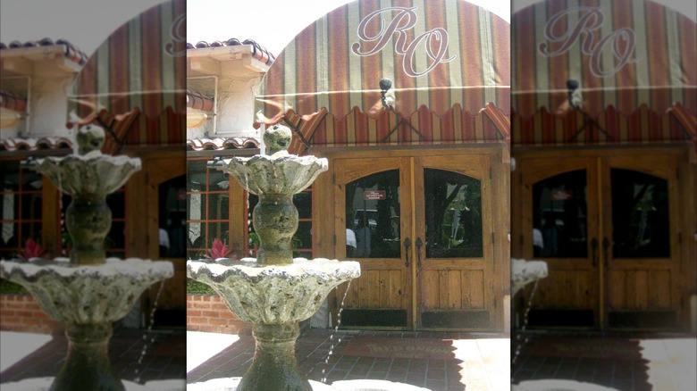Exterior of The Red Onion with faded awning and fountain