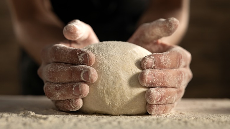 hands cupping ball of dough
