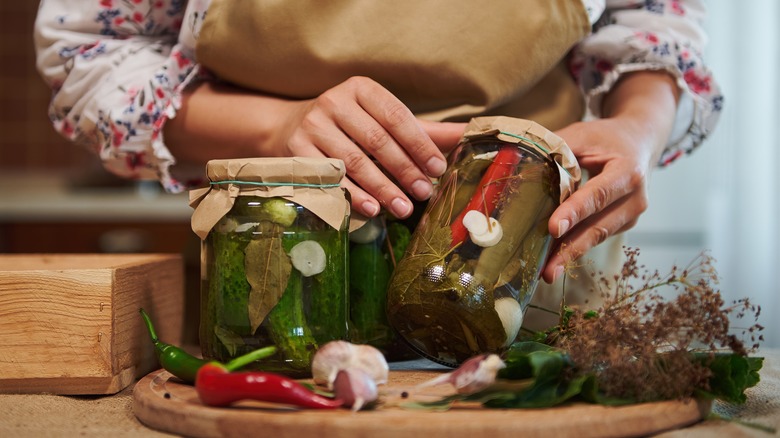 Person inspecting pickle jars