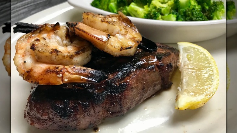 Steak and shrimp with lemon slice and broccoli