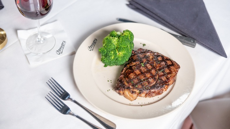Steak on plate with broccoli and glass of wine