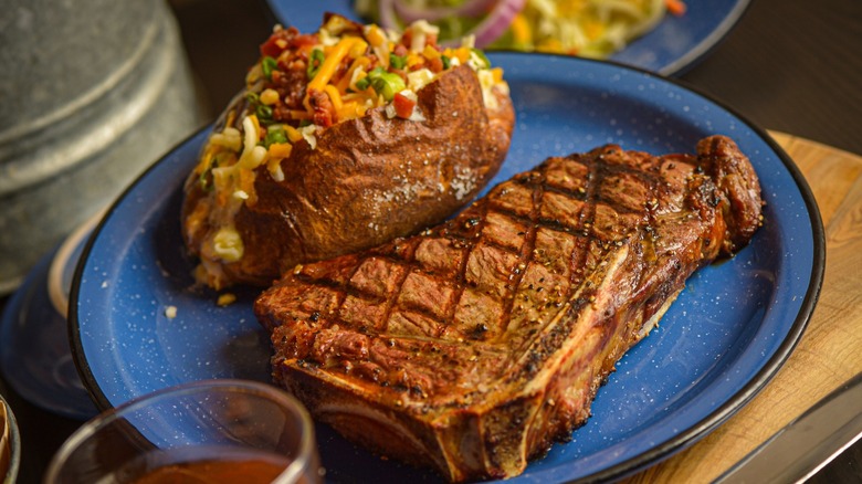 Steak and baked potato on blue plate