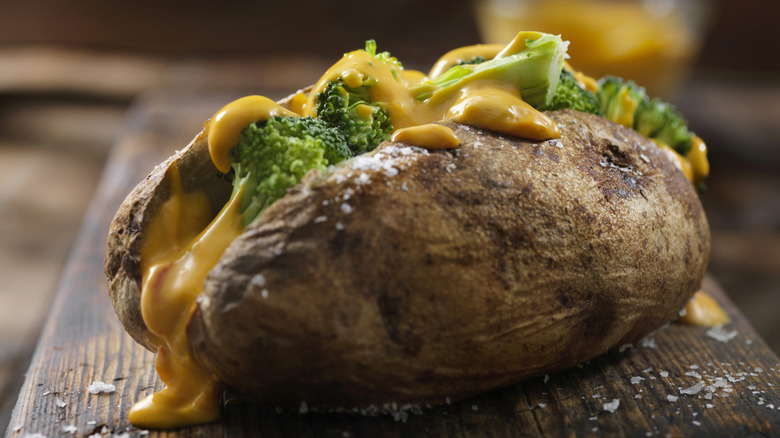 Steamed broccoli with cheese sauce on a baked potato.