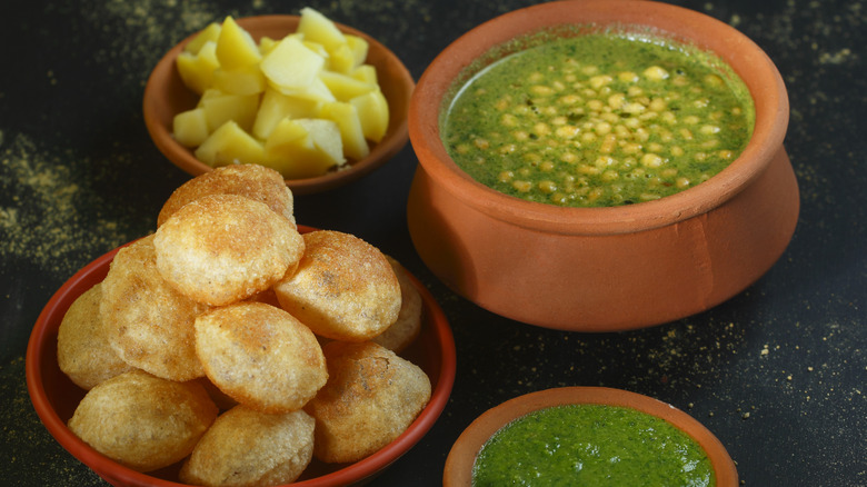 Indian Pani Puri with steamed potatoes and herb sauces.