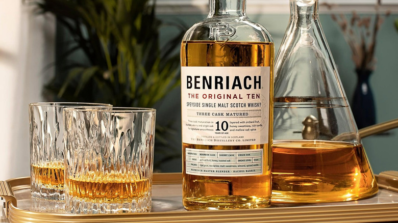 A bottle of Benriach The Original Ten on a tray with a decanter and two filled glasses