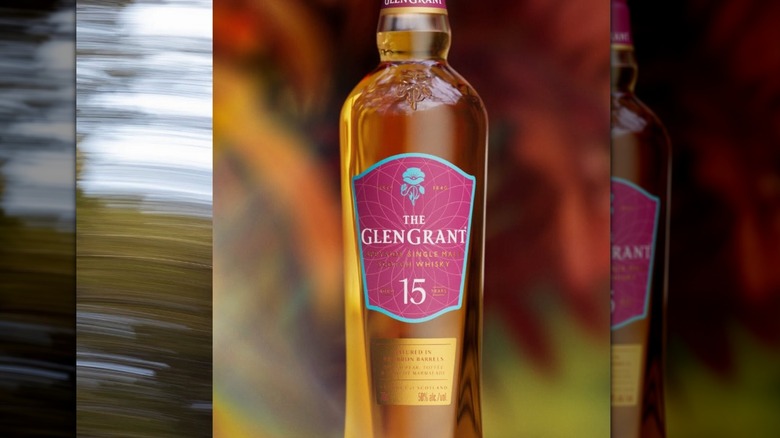 A stylized shot of a bottle of The Glen Grant 15-year with a blurred, colorful background