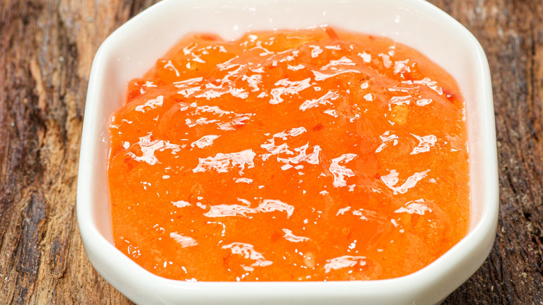 Bowl of hot pepper jelly on a wooden table