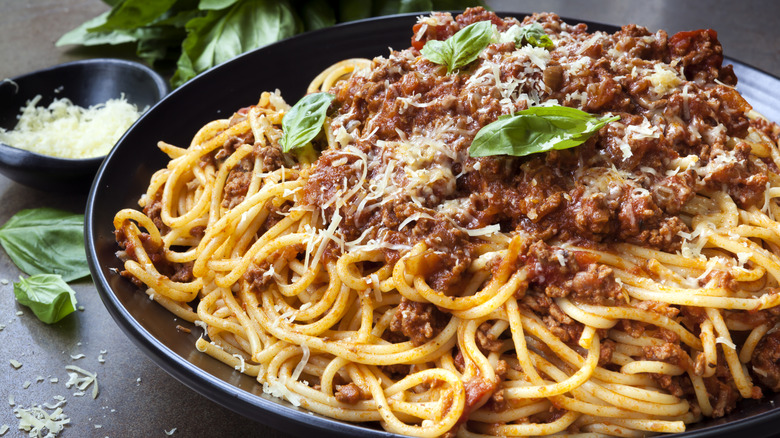 Spaghetti bolognese in black bowl