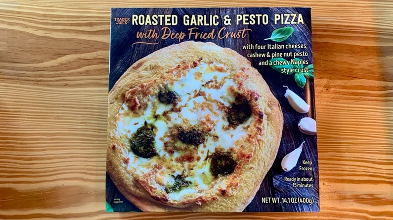 Trader Joe's Roasted Garlic and Pesto Pizza box on wooden counter