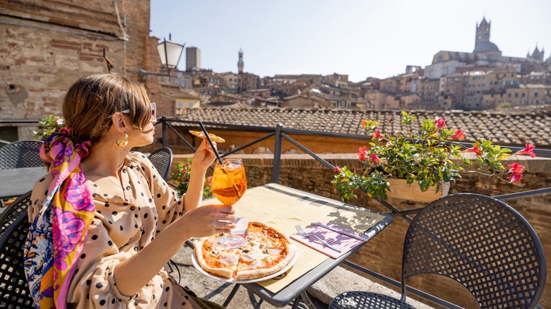 Woman eating pizza in Italy
