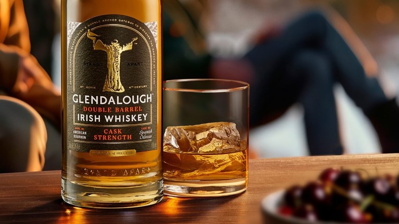 A bottle of Glendalough Irish whiskey on a table next to a filled glass