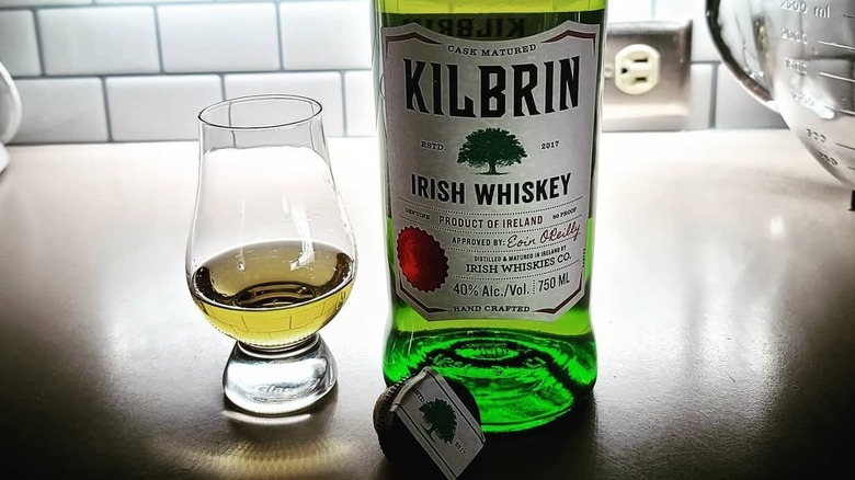 A bottle of Kilbrin Blended Irish Whiskey backlit on a countertop