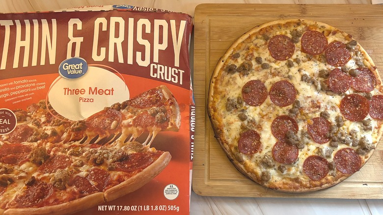 Great Value Thin & Crispy Three Meat Pizza on cutting board next to packaging