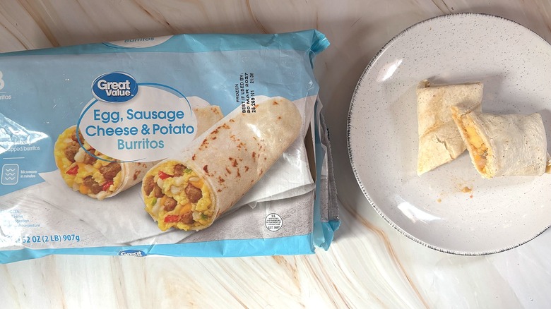 Great Value Egg Sausage Cheese Potato Burrito cut in half on white plate next to packaging